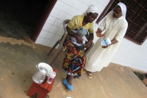 La Soeur explique à la maman de Valérie comment préparer les biberons en les stérilisant - Centre de Ndelele au CAMEROUN